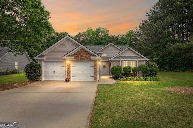 view of front of house featuring driveway, a shingled roof, a front yard, and a garage