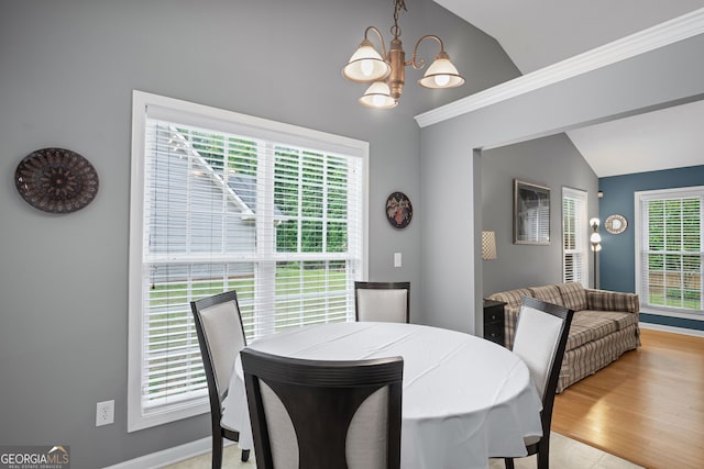 dining area with baseboards, a chandelier, and lofted ceiling