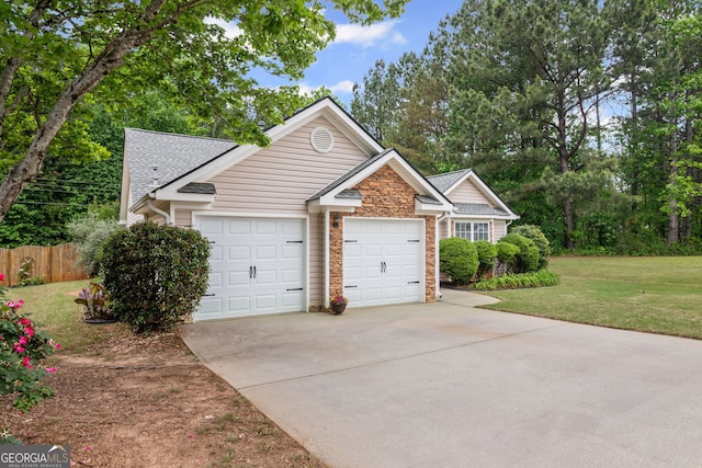 view of front of house with an attached garage, driveway, stone siding, and a front lawn