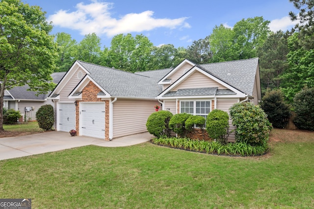 view of front of house featuring a front yard, concrete driveway, an attached garage, a shingled roof, and stone siding