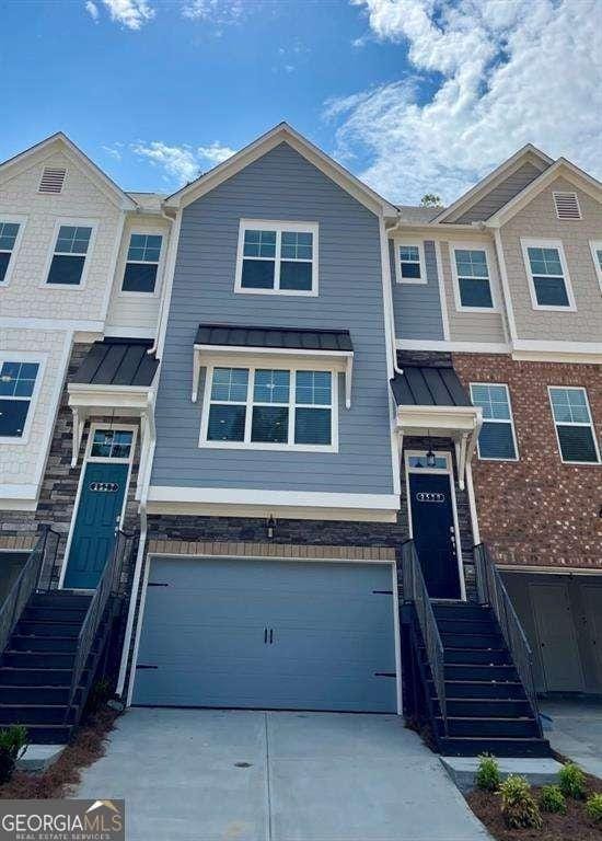 2539 Hedgeway Cir, Kennesaw, GA 30144 - view of property featuring a garage, stone siding, a standing seam roof, metal roof, and driveway