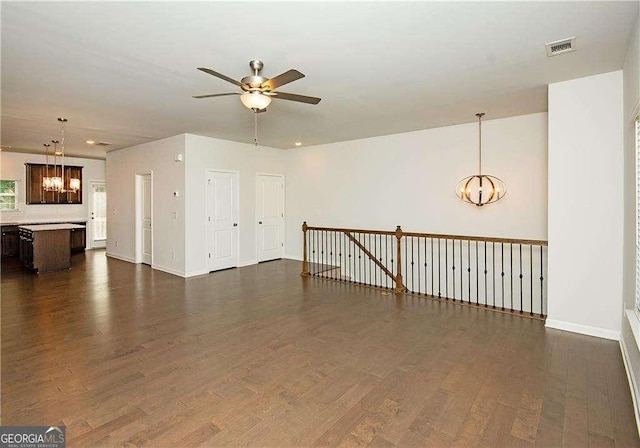 2539 Hedgeway Cir, Kennesaw, GA 30144 - empty room featuring visible vents, dark wood-style flooring, ceiling fan with notable chandelier, and baseboards