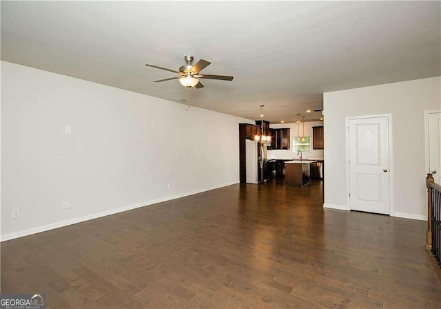 2539 Hedgeway Cir, Kennesaw, GA 30144 - unfurnished living room featuring baseboards, ceiling fan with notable chandelier, and dark wood-type flooring