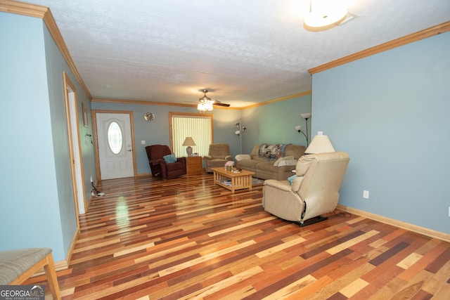living room with a ceiling fan, a textured ceiling, ornamental molding, and light wood-style floors