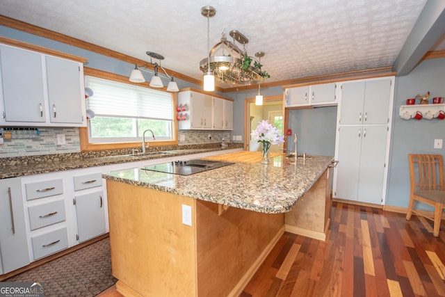 kitchen featuring decorative backsplash, light stone countertops, and black electric stovetop