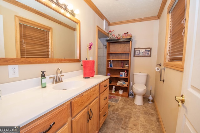 bathroom featuring stone finish floor, baseboards, vanity, toilet, and ornamental molding