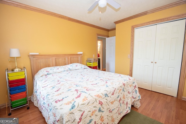 bedroom featuring a closet, ornamental molding, baseboards, a ceiling fan, and light wood finished floors