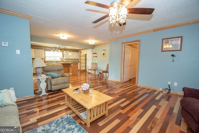 living area with baseboards, ceiling fan, ornamental molding, and light wood finished floors