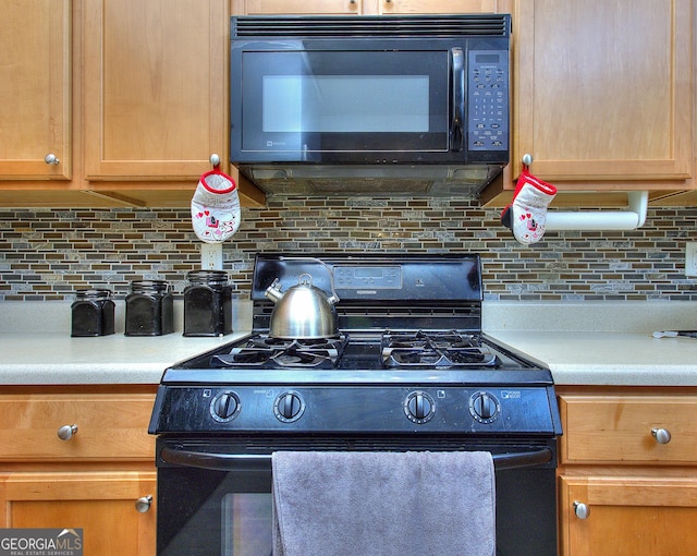 kitchen with light countertops, decorative backsplash, and black appliances