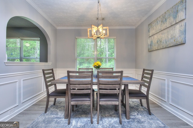 dining area with visible vents, a textured ceiling, wood finished floors, and a notable chandelier