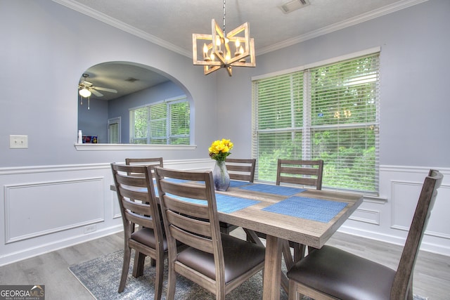dining area with visible vents, ornamental molding, wainscoting, and wood finished floors