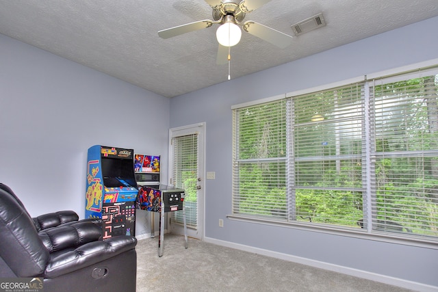 sitting room with visible vents, a ceiling fan, baseboards, a textured ceiling, and carpet flooring