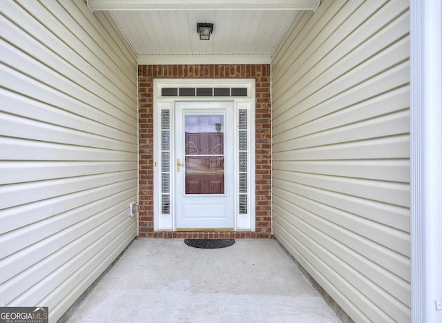 entrance to property featuring brick siding