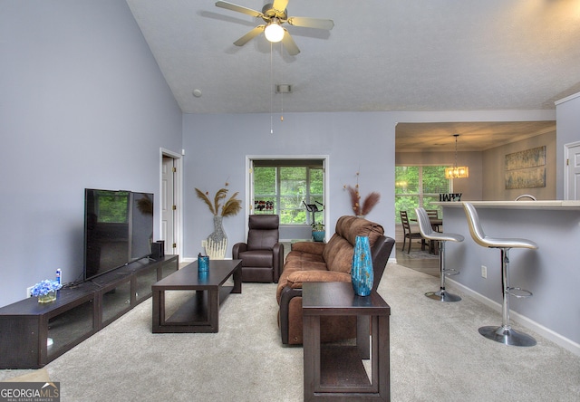 living area featuring ceiling fan with notable chandelier, baseboards, and carpet flooring
