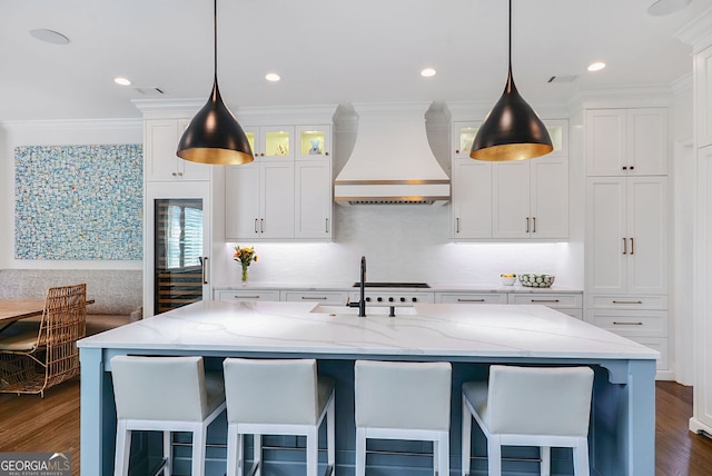 kitchen with white cabinetry, light stone counters, custom exhaust hood, and dark wood finished floors