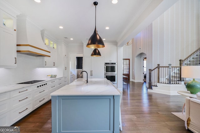 kitchen featuring glass insert cabinets, stainless steel double oven, arched walkways, white cabinets, and a sink