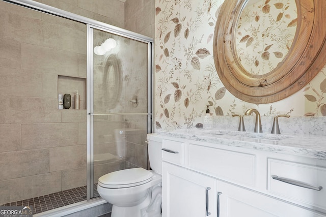 full bathroom featuring vanity, toilet, wallpapered walls, and a stall shower