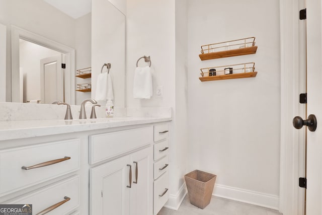 bathroom with vanity, baseboards, and tile patterned floors