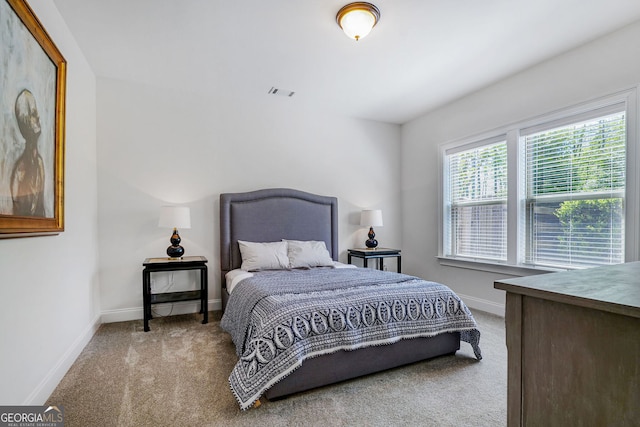 carpeted bedroom featuring baseboards and visible vents
