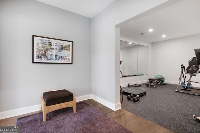 exercise room featuring baseboards, recessed lighting, and wood finished floors