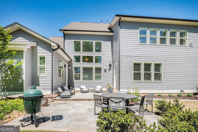 back of property featuring a patio and an outdoor living space