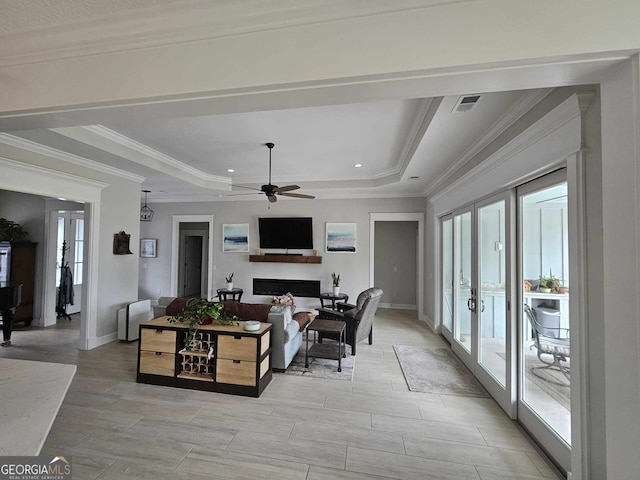 living area featuring a ceiling fan, french doors, visible vents, a fireplace, and a raised ceiling