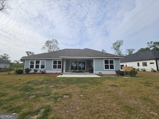 back of house with a yard, board and batten siding, and a patio area