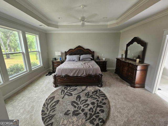 bedroom featuring crown molding, a raised ceiling, baseboards, and light carpet