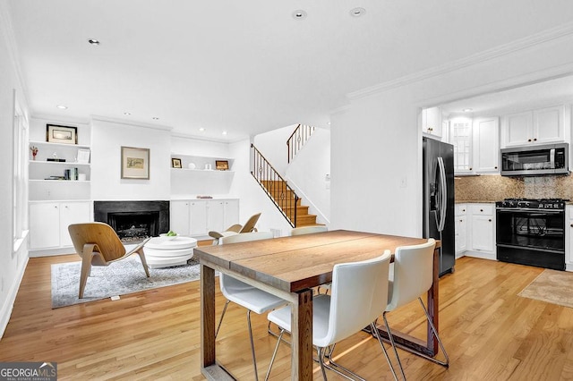 11 Ardmore Sq NW, Atlanta, GA 30309 - dining space featuring ornamental molding, stairway, a fireplace, light wood finished floors, and recessed lighting