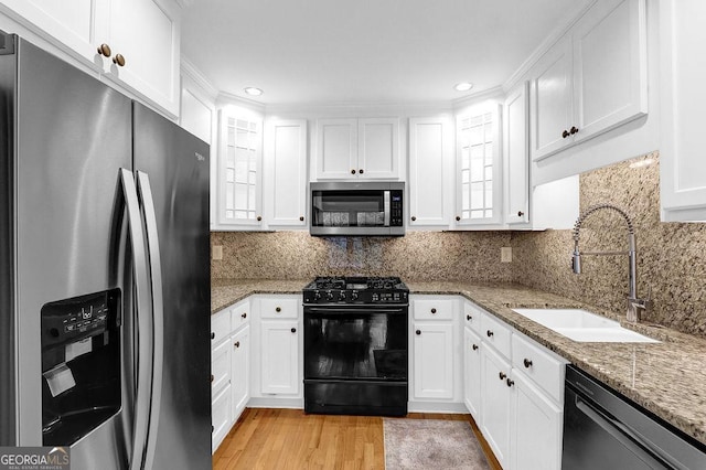 11 Ardmore Sq NW, Atlanta, GA 30309 - kitchen with appliances with stainless steel finishes, a sink, white cabinetry, glass insert cabinets, and light wood finished floors
