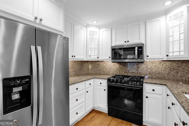 11 Ardmore Sq NW, Atlanta, GA 30309 - kitchen with stainless steel appliances, white cabinetry, glass insert cabinets, and recessed lighting