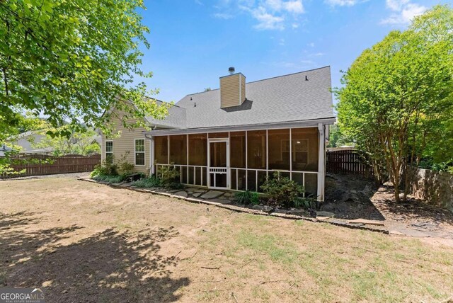 1338 Jefferson Station Rd, Jefferson, GA 30549 - back of house with a chimney, a fenced backyard, and a sunroom
