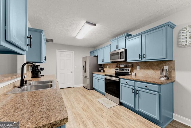 1338 Jefferson Station Rd, Jefferson, GA 30549 - kitchen with appliances with stainless steel finishes, blue cabinets, light wood-style flooring, tasteful backsplash, and a chandelier