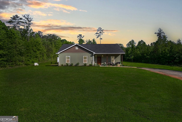 single story home featuring a front lawn, board and batten siding, and covered porch
