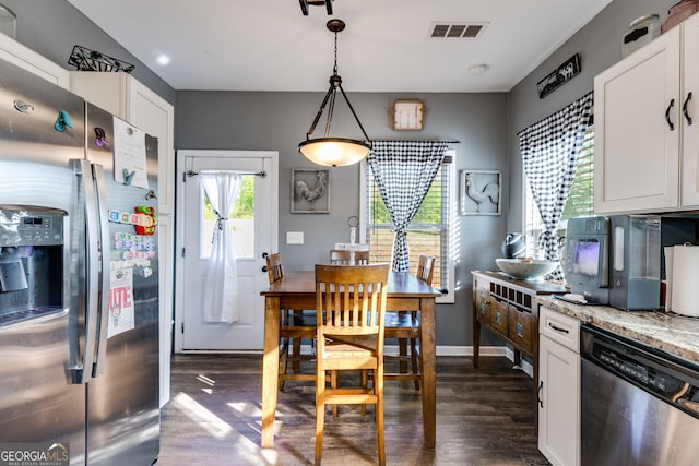kitchen with visible vents, dark wood-style flooring, white cabinets, light stone counters, and stainless steel appliances