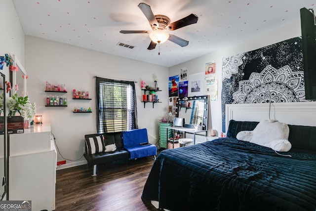 bedroom with visible vents, a ceiling fan, baseboards, and wood finished floors