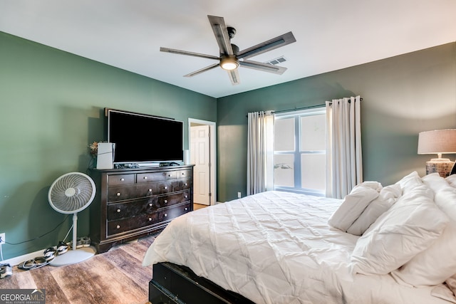bedroom featuring baseboards, a ceiling fan, and wood finished floors