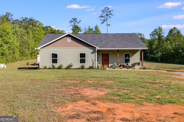 ranch-style home with board and batten siding, a porch, roof with shingles, and a front lawn