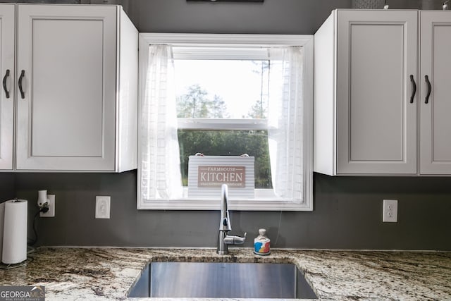 details featuring stone countertops and a sink