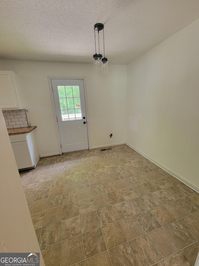 129 Carolyn Path, Rockmart, GA 30153 - unfurnished dining area with a textured ceiling and baseboards