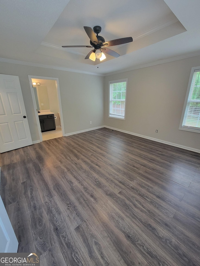 129 Carolyn Path, Rockmart, GA 30153 - unfurnished living room featuring a tray ceiling, dark wood-style floors, ceiling fan, crown molding, and baseboards