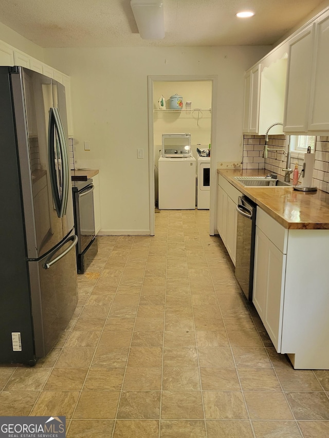 129 Carolyn Path, Rockmart, GA 30153 - kitchen with appliances with stainless steel finishes, a sink, white cabinets, independent washer and dryer, and backsplash