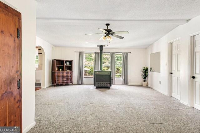 709 Tallapoosa Hwy, Cedartown, GA 30125 - unfurnished living room with heating unit, carpet floors, ceiling fan, and a wood stove