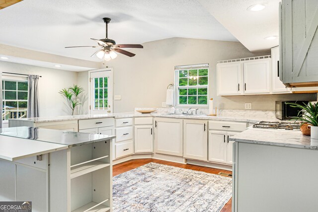 709 Tallapoosa Hwy, Cedartown, GA 30125 - kitchen featuring white cabinets, ceiling fan, light countertops, lofted ceiling, and light wood-type flooring