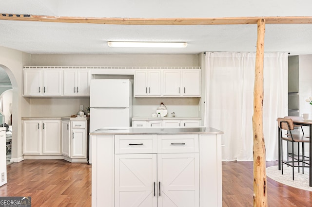 709 Tallapoosa Hwy, Cedartown, GA 30125 - kitchen featuring light wood-type flooring, arched walkways, white cabinets, and light countertops