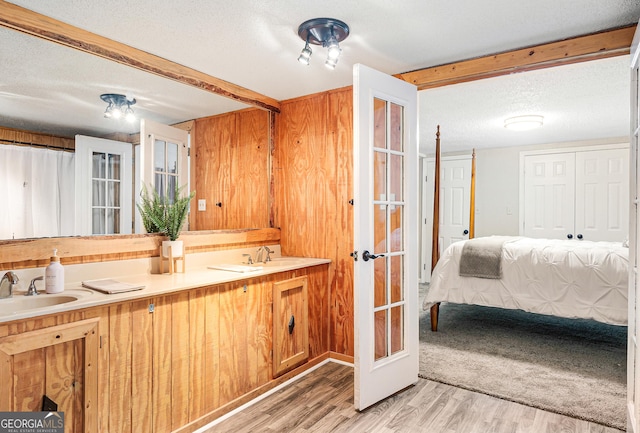 709 Tallapoosa Hwy, Cedartown, GA 30125 - full bathroom featuring french doors, a sink, a textured ceiling, and wood finished floors