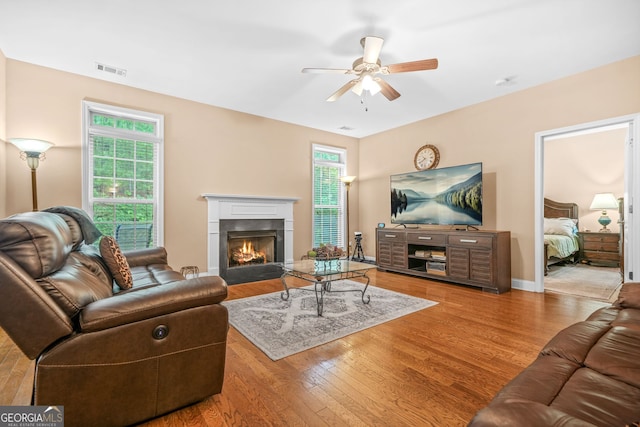 4616 Town Manor Dr, Douglasville, GA 30135 - living room with a ceiling fan, baseboards, a fireplace with flush hearth, wood finished floors, and visible vents