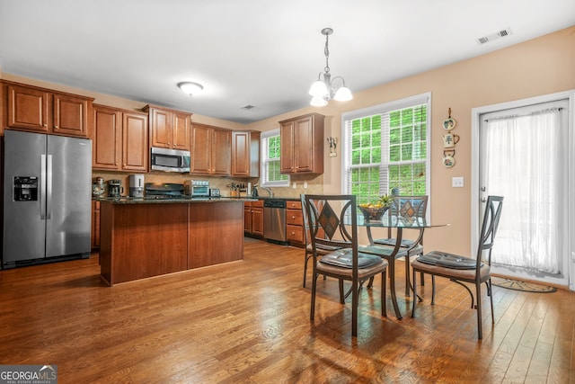4616 Town Manor Dr, Douglasville, GA 30135 - kitchen featuring a notable chandelier, stainless steel appliances, wood finished floors, a kitchen island, and visible vents