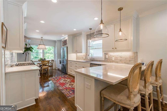 kitchen with a sink, white cabinetry, and tasteful backsplash