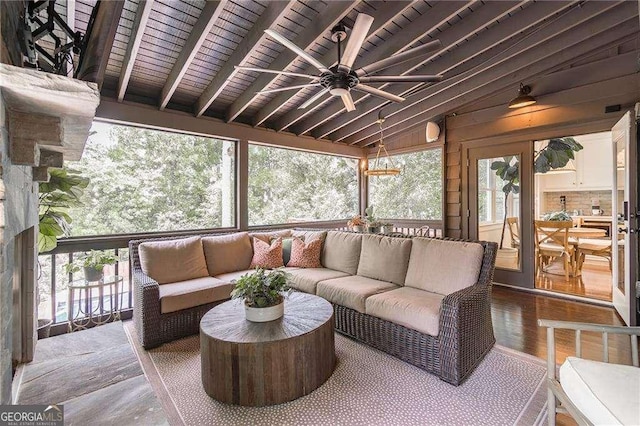 sunroom / solarium featuring ceiling fan, lofted ceiling with beams, wooden ceiling, and outdoor lounge area